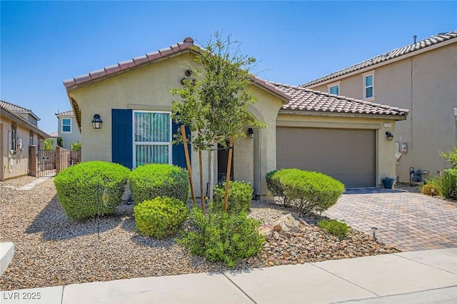 7224 Piute Mesa St, North Las Vegas, NV 89084 - mediterranean / spanish-style home featuring a garage, driveway, a tiled roof, stucco siding, and a gate