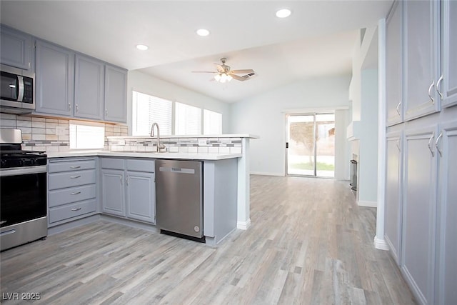 5233 Camino Del Rancho, Las Vegas, NV 89130 - kitchen with stainless steel appliances, gray cabinets, a peninsula, backsplash, and a ceiling fan
