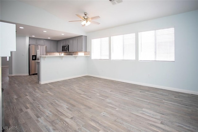 5233 Camino Del Rancho, Las Vegas, NV 89130 - kitchen with appliances with stainless steel finishes, gray cabinets, a peninsula, ceiling fan, and open floor plan