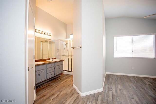 5233 Camino Del Rancho, Las Vegas, NV 89130 - bathroom with double vanity, wood finished floors, a stall shower, and vaulted ceiling