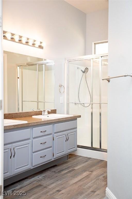 5233 Camino Del Rancho, Las Vegas, NV 89130 - full bath with double vanity, a stall shower, and wood finished floors