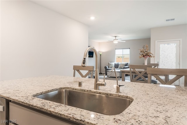 7910 Shimmery St, North Las Vegas, NV 89084 - kitchen with light stone countertops, ceiling fan, and open floor plan