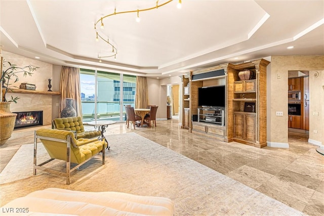2877 Paradise Rd Unit 702, Las Vegas, NV 89109 - living area featuring a tray ceiling, a premium fireplace, and ornate columns