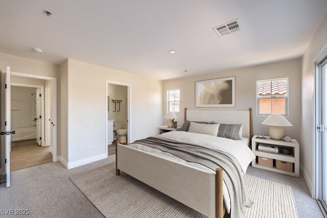 1097 Paradise Resort Dr, Henderson, NV 89002 - bedroom featuring light colored carpet, multiple windows, and connected bathroom