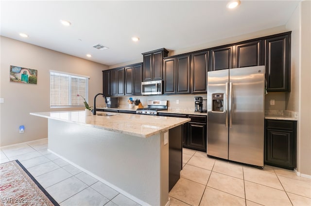 2861 Sunflower Days Ave Unit 1144, North Las Vegas, NV 89031 - kitchen with stainless steel appliances, a kitchen island with sink, light stone counters, light tile patterned flooring, and recessed lighting