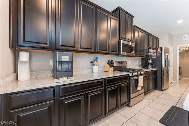 2861 Sunflower Days Ave Unit 1144, North Las Vegas, NV 89031 - kitchen with appliances with stainless steel finishes, light tile patterned floors, and light stone countertops