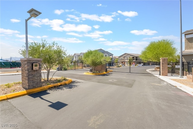2861 Sunflower Days Ave Unit 1144, North Las Vegas, NV 89031 - view of asphalt road featuring a gate, curbs, a gated entry, and a residential view