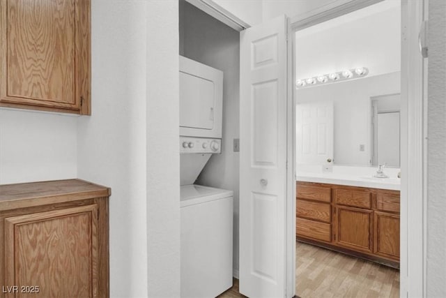 5155 W Tropicana Ave Unit 2017, Las Vegas, NV 89103 - washroom featuring estacked washer and dryer and light wood-style floors