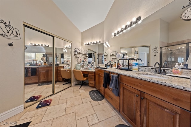 2637 Ohio Ct, Las Vegas, NV 89128 - full bathroom featuring a shower stall, vanity, stone tile floors, and high vaulted ceiling