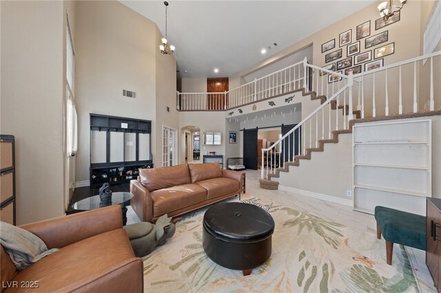 2637 Ohio Ct, Las Vegas, NV 89128 - living area with stairway, arched walkways, marble look tile flooring, a chandelier, and a high ceiling