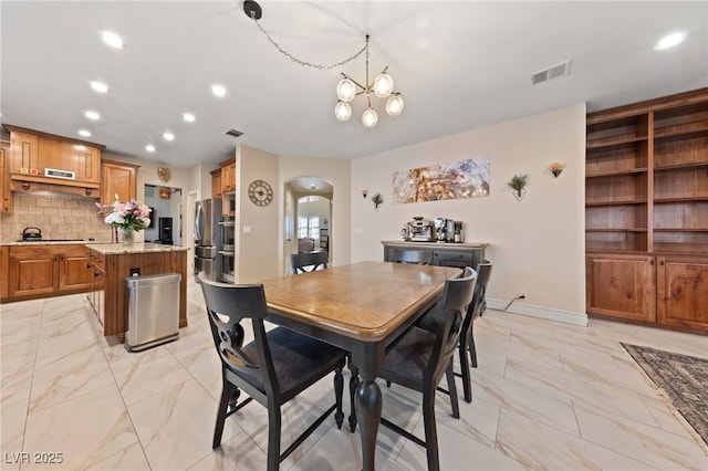 2637 Ohio Ct, Las Vegas, NV 89128 - dining space featuring arched walkways, light marble finish floors, recessed lighting, and a chandelier
