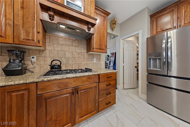 2637 Ohio Ct, Las Vegas, NV 89128 - kitchen with stainless steel appliances, under cabinet range hood, brown cabinets, and backsplash