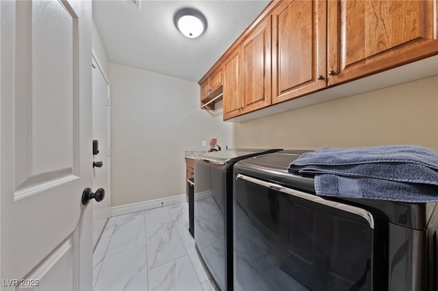 2637 Ohio Ct, Las Vegas, NV 89128 - laundry area featuring independent washer and dryer, cabinet space, light marble finish flooring, and a textured ceiling