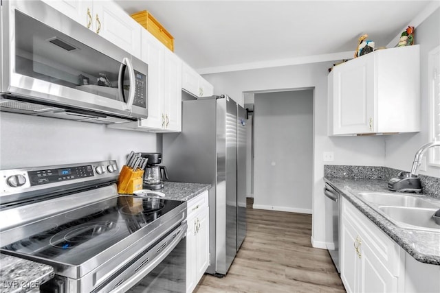 3499 Middlebury Ave, Las Vegas, NV 89121 - kitchen with stainless steel appliances, white cabinets, light wood-style floors, and light stone counters