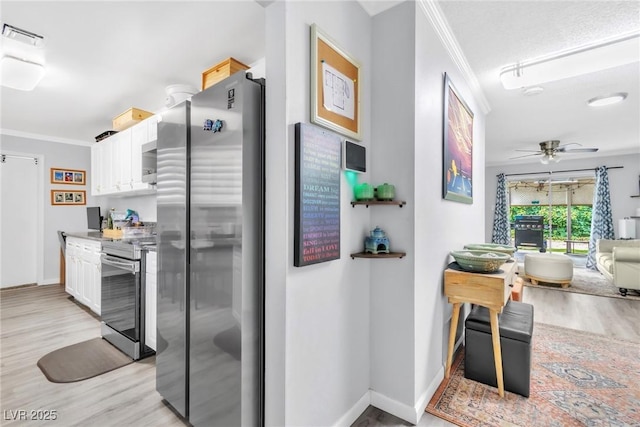 3499 Middlebury Ave, Las Vegas, NV 89121 - kitchen with stainless steel appliances, ornamental molding, white cabinetry, light wood finished floors, and ceiling fan