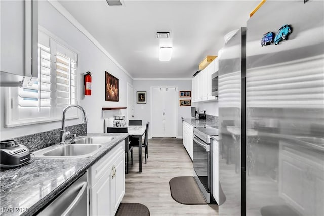 3499 Middlebury Ave, Las Vegas, NV 89121 - kitchen featuring appliances with stainless steel finishes, ornamental molding, white cabinetry, and light wood-style flooring