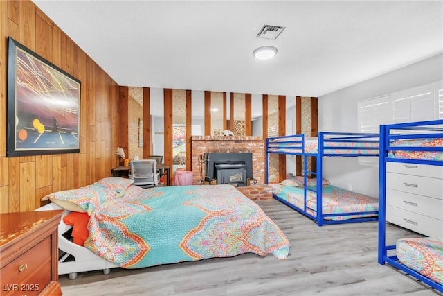 3499 Middlebury Ave, Las Vegas, NV 89121 - bedroom with wood walls, wood finished floors, and a wood stove