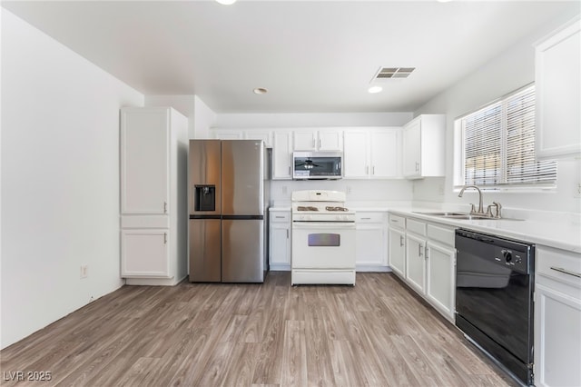 2149 Clancy St, Las Vegas, NV 89156 - kitchen with appliances with stainless steel finishes, white cabinetry, light wood-style floors, light countertops, and recessed lighting
