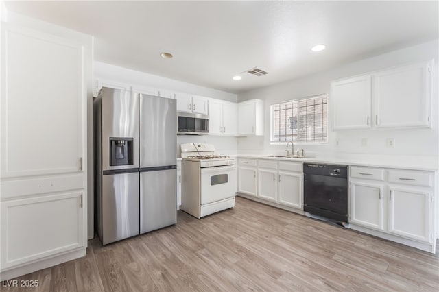2149 Clancy St, Las Vegas, NV 89156 - kitchen featuring stainless steel appliances, white cabinets, light wood-style flooring, light countertops, and recessed lighting