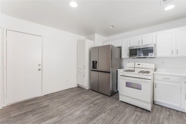 2149 Clancy St, Las Vegas, NV 89156 - kitchen featuring stainless steel appliances, white cabinetry, light countertops, light wood finished floors, and recessed lighting