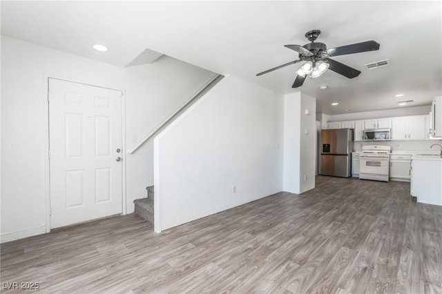 2149 Clancy St, Las Vegas, NV 89156 - unfurnished living room with stairs, light wood-type flooring, recessed lighting, and a ceiling fan