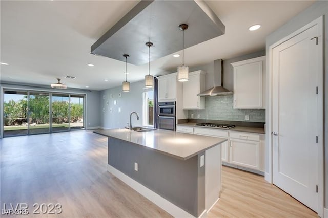 10342 Kesington Dr, Las Vegas, NV 89135 - kitchen with wall chimney range hood, white cabinets, light wood-style floors, decorative backsplash, and recessed lighting