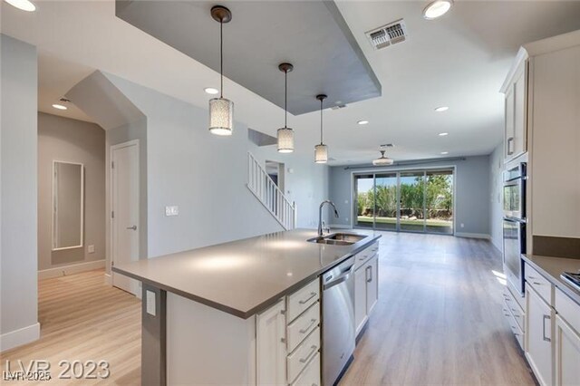 10342 Kesington Dr, Las Vegas, NV 89135 - kitchen featuring stainless steel appliances, open floor plan, light wood-style flooring, pendant lighting, and dark countertops