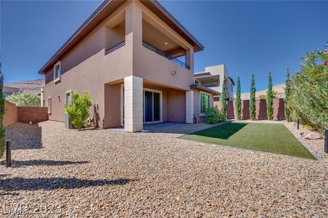 10342 Kesington Dr, Las Vegas, NV 89135 - rear view of house with stucco siding, a balcony, and a fenced backyard