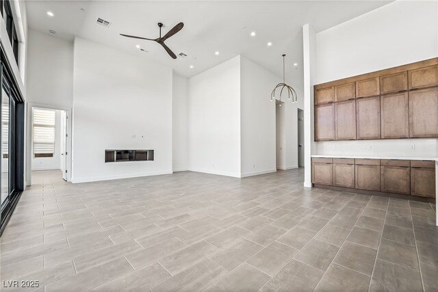 10919 Vista Altura Ave, Las Vegas, NV 89135 - unfurnished living room featuring a towering ceiling, ceiling fan, and recessed lighting