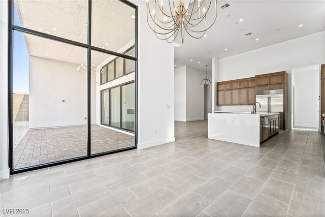 10919 Vista Altura Ave, Las Vegas, NV 89135 - unfurnished living room featuring a towering ceiling, a chandelier, and recessed lighting