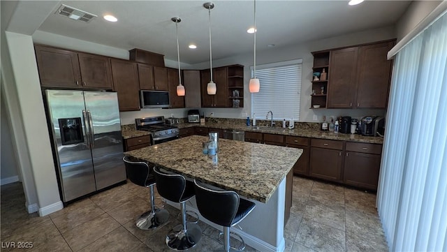 10668 Berkshire Woods Ave, Las Vegas, NV 89166 - kitchen with stainless steel appliances, open shelves, dark brown cabinetry, dark stone counters, and a center island