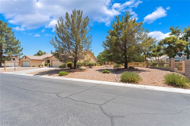 4909 Desert Poppy Dr, Las Vegas, NV 89130 - view of property hidden behind natural elements featuring driveway, an attached garage, and stucco siding