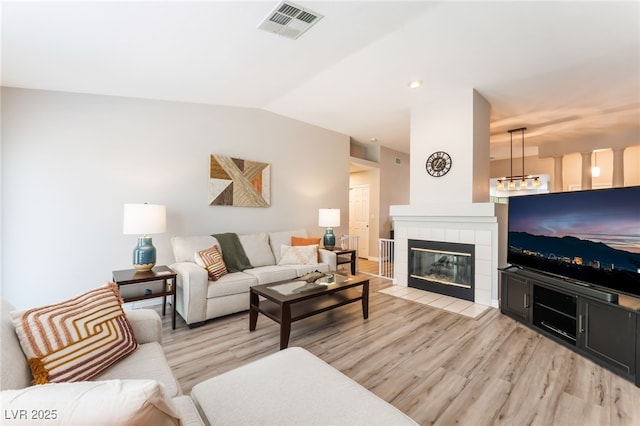 4909 Desert Poppy Dr, Las Vegas, NV 89130 - living room with light wood-style flooring, vaulted ceiling, and a fireplace