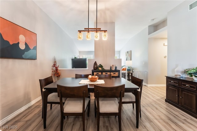 4909 Desert Poppy Dr, Las Vegas, NV 89130 - dining area featuring light wood-type flooring, a chandelier, and lofted ceiling