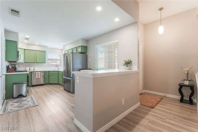 4909 Desert Poppy Dr, Las Vegas, NV 89130 - kitchen featuring green cabinetry, appliances with stainless steel finishes, light wood-style flooring, light countertops, and decorative light fixtures