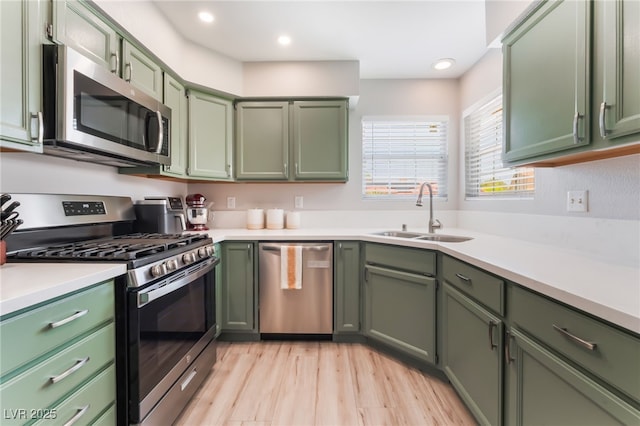 4909 Desert Poppy Dr, Las Vegas, NV 89130 - kitchen with stainless steel appliances, green cabinets, light countertops, light wood finished floors, and recessed lighting