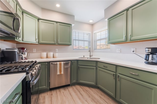 4909 Desert Poppy Dr, Las Vegas, NV 89130 - kitchen with green cabinets, appliances with stainless steel finishes, light countertops, light wood finished floors, and recessed lighting