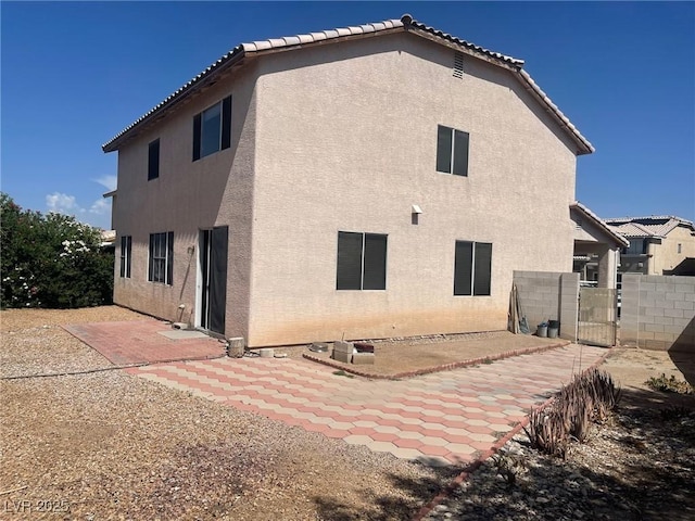 1278 N Sloan Ln, Las Vegas, NV 89110 - back of house featuring stucco siding, a patio, a gate, and a tile roof