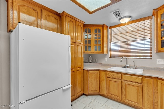 825 W Ryan Ave, Overton, NV 89040 - kitchen featuring freestanding refrigerator, glass insert cabinets, light tile patterned flooring, and light countertops