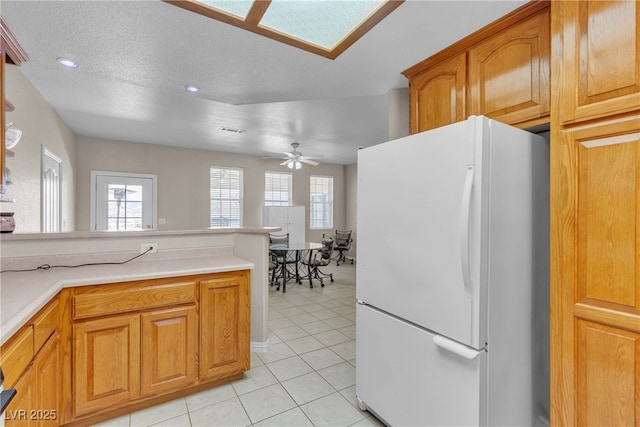 825 W Ryan Ave, Overton, NV 89040 - kitchen with freestanding refrigerator, ceiling fan, light tile patterned flooring, brown cabinetry, and recessed lighting