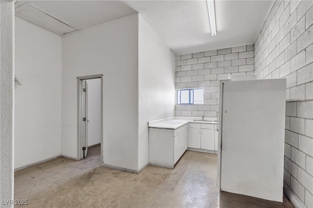 825 W Ryan Ave, Overton, NV 89040 - kitchen featuring freestanding refrigerator, concrete floors, light countertops, and white cabinetry