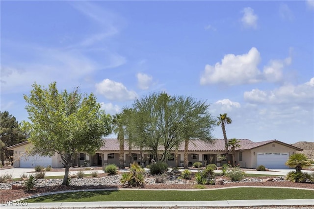 825 W Ryan Ave, Overton, NV 89040 - view of front of property featuring driveway, a garage, a tile roof, and stucco siding