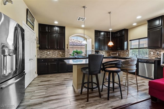 6705 Philharmonic Ave, Las Vegas, NV 89139 - kitchen featuring appliances with stainless steel finishes, healthy amount of natural light, a kitchen island, light wood-type flooring, and recessed lighting