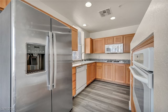 23 E Agate Ave Unit 308, Las Vegas, NV 89123 - kitchen with white appliances, light wood finished floors, recessed lighting, light stone counters, and light brown cabinets