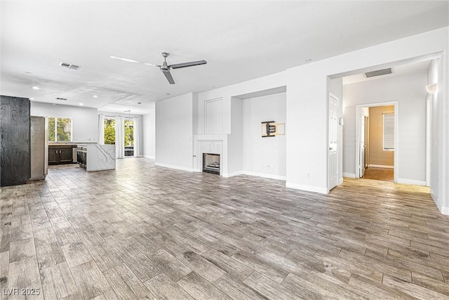 3257 Rushing Waters Pl, Las Vegas, NV 89135 - unfurnished living room featuring ceiling fan, wood finished floors, a fireplace, and recessed lighting