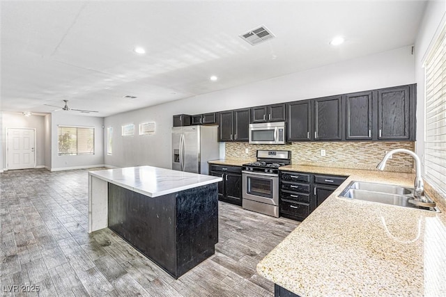 3257 Rushing Waters Pl, Las Vegas, NV 89135 - kitchen featuring appliances with stainless steel finishes, a kitchen island, light wood finished floors, light countertops, and recessed lighting