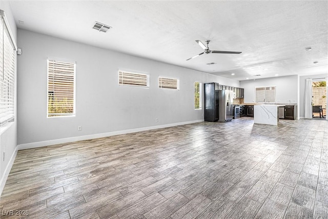 3257 Rushing Waters Pl, Las Vegas, NV 89135 - unfurnished living room with a ceiling fan, light wood-style flooring, and a textured ceiling