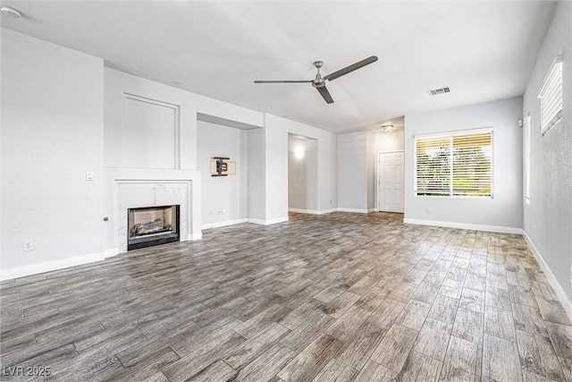 3257 Rushing Waters Pl, Las Vegas, NV 89135 - unfurnished living room featuring a ceiling fan, wood finished floors, and a premium fireplace