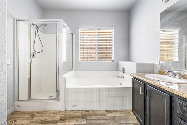 3257 Rushing Waters Pl, Las Vegas, NV 89135 - bathroom with vanity, a bath, a stall shower, and wood finished floors