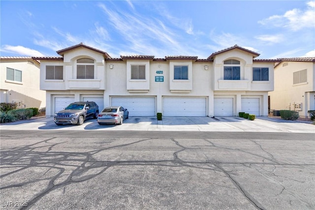 4820 Grey Wolf Ln Unit 101, Las Vegas, NV 89149 - view of front facade with an attached garage, stucco siding, driveway, and a tiled roof